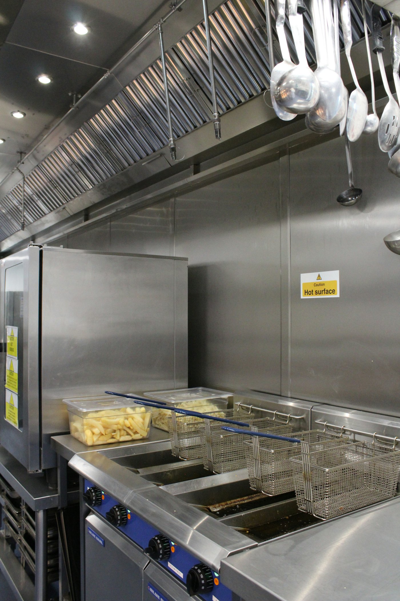 Stainless baffle filters in a canopy above commercial deep fryers